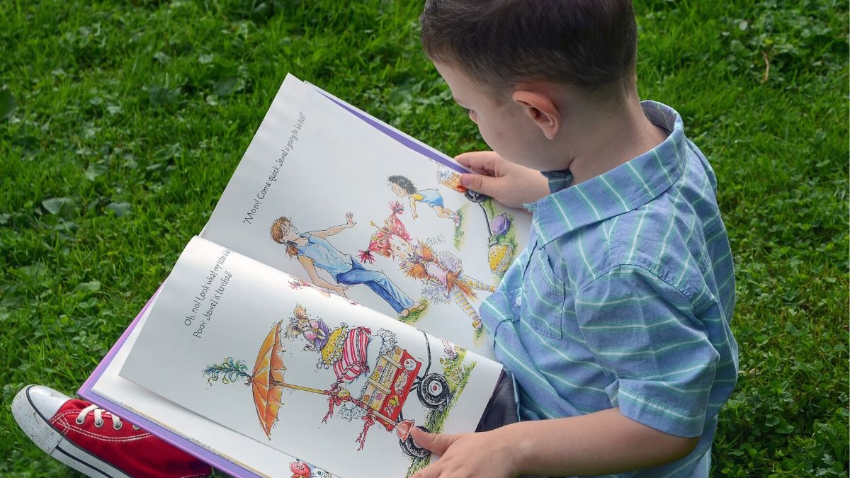 image toddler boy reading picture book